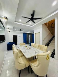 a dining room with a table and a ceiling fan at Paddy View Homestay in Kangar