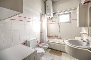 a bathroom with a sink and a toilet and a tub at Nicolas Home in Tríkala