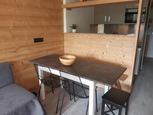 a small kitchen with a table and two chairs at Appartement rénové 2 pièces cabine avec balcon - 6 personnes - Wifi inclus - FR-1-346-558 in Arc 1800 +16 photos