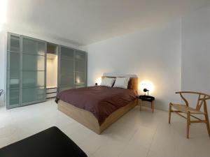 聖克魯斯－德特內里費的住宿－Suite la Colina，一间卧室配有一张床和一把椅子