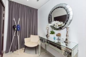 a dressing table with a mirror and a chair at VayK - Modern 2BD in the Marina near Beach in Dubai