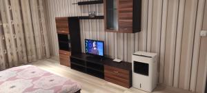 een kamer met een tv op een dressoir met een bed bij Apartament Kostov Sliven in Sliven