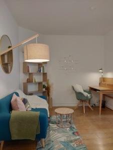 a living room with a blue couch and a table at Appartement tout équipé au cœur de Fontainebleau in Fontainebleau