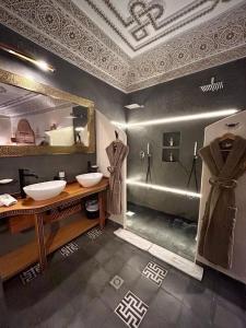 La salle de bains est pourvue de 2 lavabos et d'un grand miroir. dans l'établissement Riad Al Nubala, à Marrakech