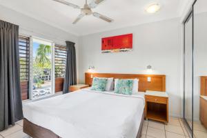 a bedroom with a large bed and a window at Bay Village Tropical Retreat & Apartments in Cairns +76 photos