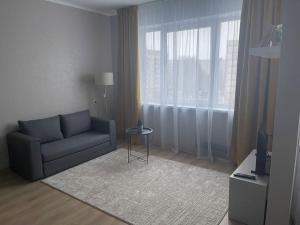 a living room with a blue couch and a table at Cozy apartment close to Riga Airport in Riga