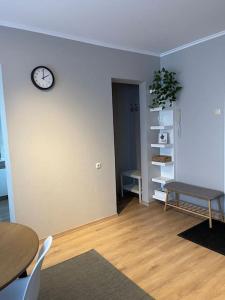um quarto com uma mesa e um relógio na parede em Cozy apartment close to Riga Airport em Riga