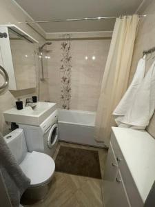 Cozy apartment close to Riga Airport في ريغا: حمام مع مرحاض ومغسلة وحوض استحمام