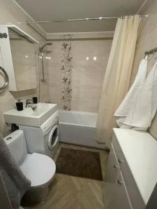 a bathroom with a toilet and a sink and a tub at Cozy apartment close to Riga Airport in Rīga