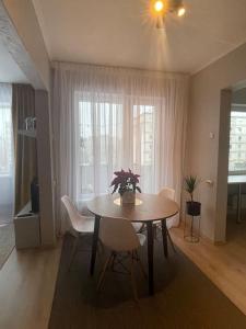 a dining room with a table and chairs and a window at Cozy apartment close to Riga Airport in Rīga