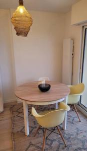 a dining room table with two chairs and a bowl on it at Le Verdi - Les Gîtes de la Côte d'Amour in Le Croisic +9 photos