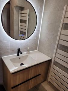 La salle de bains est pourvue d'un lavabo et d'un miroir. dans l'établissement Le Verdi - Les Gîtes de la Côte d'Amour, au Croisic