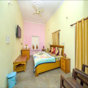 a bedroom with a bed and a desk and a tv at Khajuraho Rancho in Khajurāho