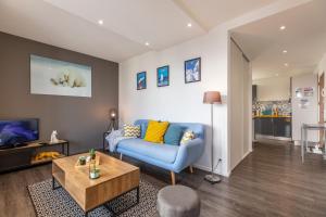 a living room with a blue couch and a table at Le COCON de Jaude F2 HyperCentre avec ascenseur 52Bonnabaud in Clermont-Ferrand