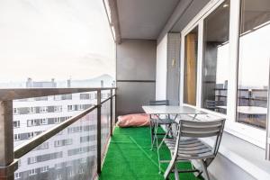 - un balcon avec une table et des chaises et un sol vert dans l'établissement Le COCON de Jaude F2 HyperCentre avec ascenseur 52Bonnabaud, à Clermont-Ferrand