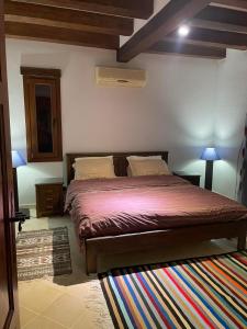 sypialnia z łóżkiem z kolorowym dywanem w obiekcie SANDROSE w mieście Tauzar