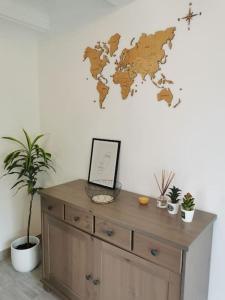 a wooden dresser with a world map on the wall at Maisonnette rénovée et son jardin in Châtellerault