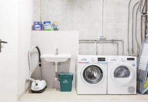 a bathroom with a washing machine and a sink at SalvatoreHomes - Luxury Villa with private Garden & BBQ in San Zeno di Montagna