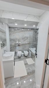 łazienka z 2 umywalkami i 2 toaletami w obiekcie Аэропорт Апартаменты 24&24 w Kiszyniowie
