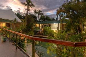 a resort with a swimming pool and palm trees at Bay Village Tropical Retreat & Apartments in Cairns