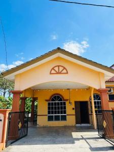a yellow house with a gate in front of it at Homestay Ira Jaya - 4 Unit Rumah in Kangar