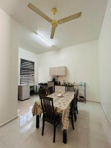 a dining room table with chairs and a ceiling fan at Homestay Ira Jaya - 4 Unit Rumah in Kangar