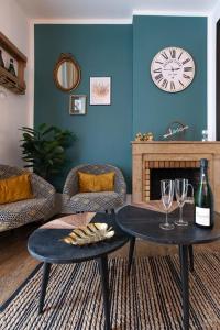 a living room with two tables and a clock on the wall at Loveappart21 l'expérience Bien Être in Dijon +19 photos