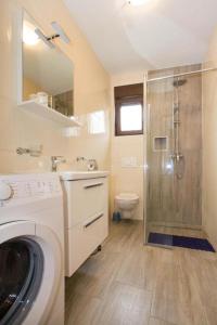 a bathroom with a shower and a washing machine at Villa Patricija-apartmani in Poreč