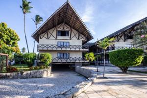 a building with palm trees in front of it at Pé na Areia no Cumbuco - Eco Paradise 110 in Caucaia