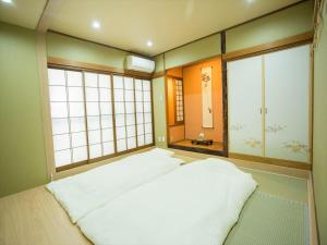 duże łóżko w pokoju z dwoma dużymi oknami w obiekcie Kyoto - House / Vacation STAY 73616 w mieście Kioto