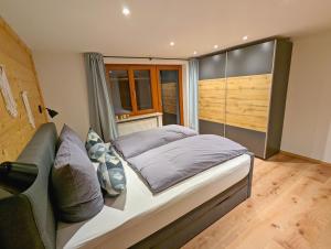 ein Schlafzimmer mit einem Bett, einem Sofa und einem Fenster in der Unterkunft Ferienwohnung Stuimändle in Obermaiselstein