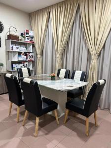 comedor con mesa y sillas en BOTANI LOFT HOMESTAY, en Ipoh