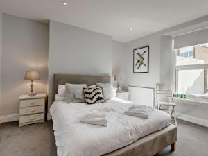 a bedroom with a large white bed and a window at 3 Bed in Brixham 78602 in Brixham