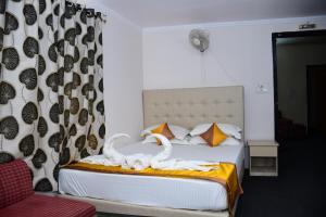 a bedroom with a bed with swans on it at Hotel Dolphin in Digha