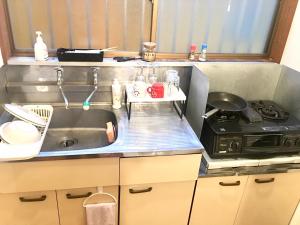 a small kitchen with a sink and a stove at 10 minutes direct to Shibuya Crossing! Heart of Tokyo! Kamiuma in Tokyo
