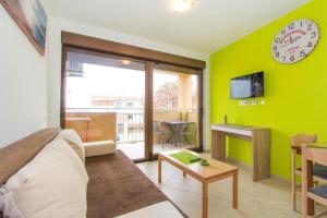 a living room with a couch and a clock on the wall at Villa Patricija-apartmani in Poreč