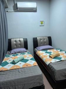 2 Betten nebeneinander in einem Zimmer in der Unterkunft BOTANI LOFT HOMESTAY in Ipoh