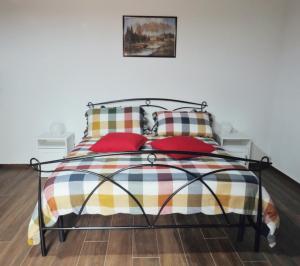 a bedroom with a bed with red pillows at Il Rifugio delle Rose in Ronciglione