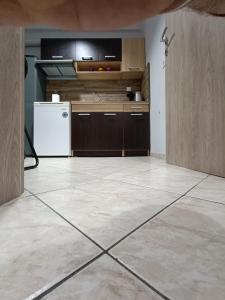 an empty room with a kitchen with a refrigerator at Thes house in Thessaloniki