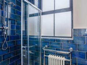 uma casa de banho em azulejos azuis com um chuveiro e um radiador em 3 Bed in Harrogate 86490 em Harrogate