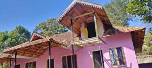 馬蒂寇裡的住宿－Green Coorg Homestay，粉红色的房子,有棕色的屋顶