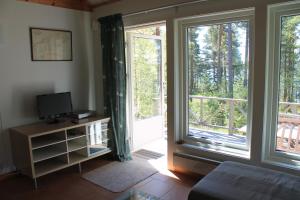 Gärdsholmens Skärgårdshemman "Eken" في Edsbruk: غرفة معيشة بها نافذتين كبيرتين وتلفزيون