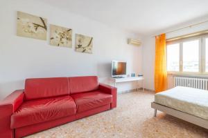 een woonkamer met een rode bank en een bed bij Ambra's bright apartment in Rome
