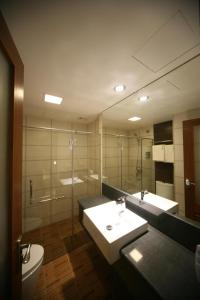 une salle de bain avec un lavabo, des toilettes et un miroir dans l'établissement Cardogan Hotel, à Kuala Lumpur