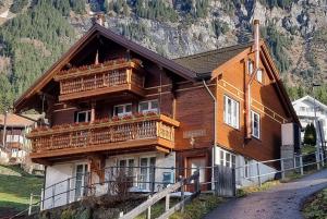 a wooden house with balconies on a mountain at Chalet Lobhornblick in Wengen