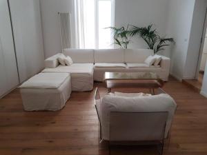 een woonkamer met een witte bank en een tafel bij Casa Guido Eco Friendly in Lecce