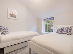 a white bedroom with two beds and a window at 2 Bed in Glenridding SZ178 in Glenridding