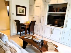 a living room with a table and a tv at Luxury 4 poster lakefront rural retreat in Heckfield