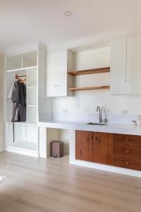 a kitchen with white cabinets and a sink at The Nordic House in Bacnotan