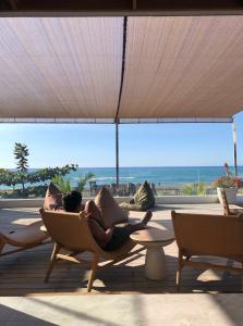 a woman laying on a chair in a room with the ocean at The Nordic House in Bacnotan